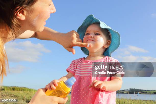 mother putting sun cream on toddler girl - spf 30 stock-fotos und bilder