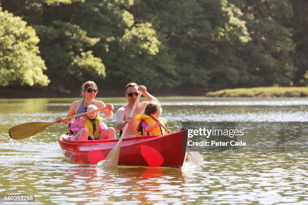 family in canoe on river - family red canoe stock pictures, royalty-free photos & images