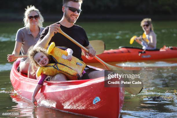 family on river in kayak and canoe - family red canoe stock pictures, royalty-free photos & images