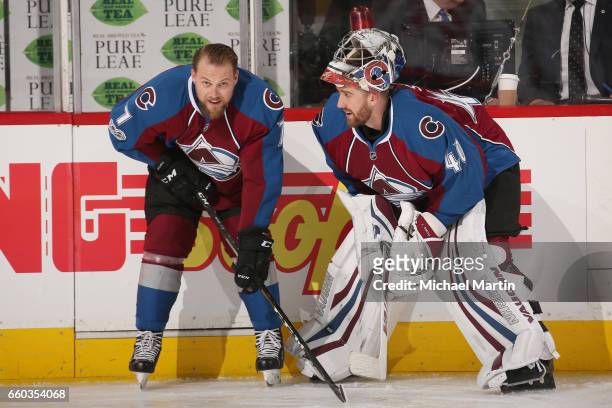 John Mitchell and goaltender Jeremy Smith of the Colorado Avalanche talk during warm ups, prior to the game against the Washington Capitals at the...