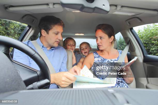 family in car, parents looking at map - lost generation stock pictures, royalty-free photos & images