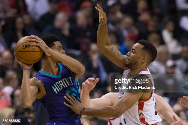 Charlotte Hornets forward Marvin Williams is defended by Toronto Raptors guard Norman Powell . Toronto Raptors vs Charlotte Hornets in 1st half...