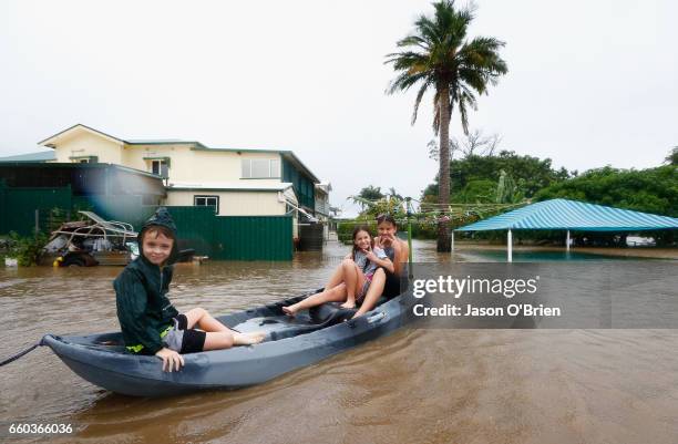 Keara,Lacey and Erich Stewart paddle in a kayak after flood waters entered there back yard on March 30, 2017 in Murwillumbah, Australia. Heavy rain...