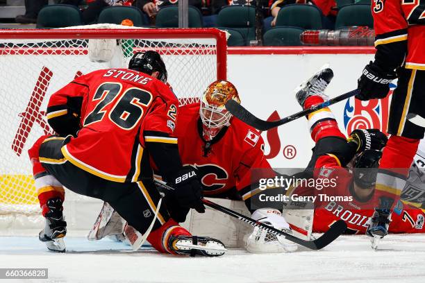 Brian Elliott and Michael Stone of the Calgary Flames look for the rebound against the Los Angeles Kings during an NHL game on March 29, 2017 at the...