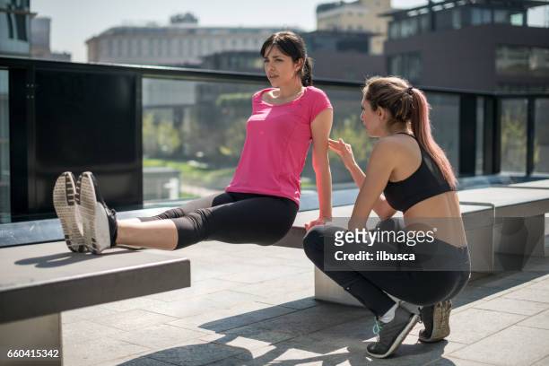 personal trainer - urban running: exercise trainer support - running coach stock pictures, royalty-free photos & images