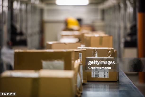 vakken op lopende band - boxes conveyor belt stockfoto's en -beelden