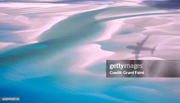 view of plane shadow on beach. - whitehaven beach stock pictures, royalty-free photos & images