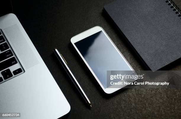 elegance top view shot of laptop, pen, smart phone and black note pad - stationery elegant stockfoto's en -beelden