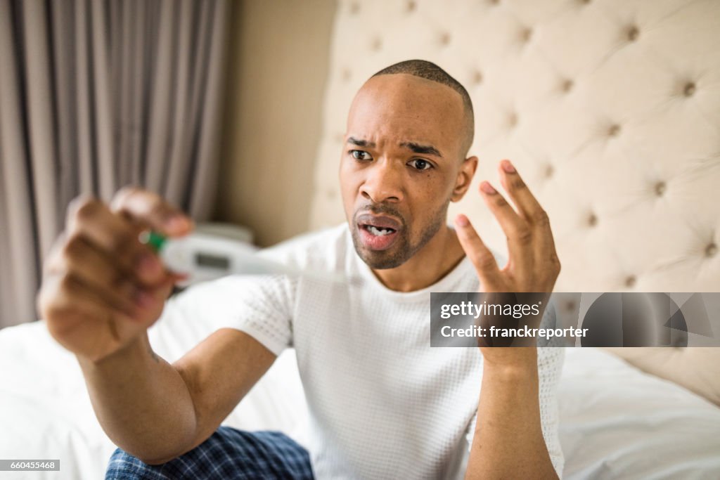 Man checking the fever on the thermometer