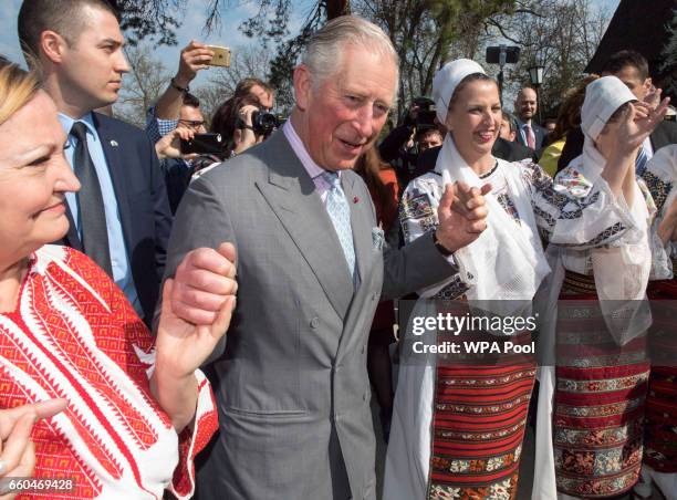 Prince Charles, Prince of Wales dances with Romanian dancers at a village museum on the second day of his nine day European tour on March 30, 2017 in...