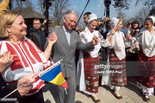 Prince Charles, Prince of Wales dances with Romanian dancers at a village museum on the second day of his nine day European tour on March 30, 2017 in...