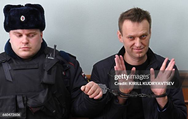 Kremlin critic Alexei Navalny, who was arrested during March 26 anti-corruption rally, gestures during an appeal hearing at a court in Moscow on...