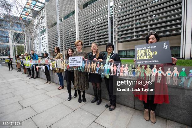 British actress Juliet Stevenson is joined by activists as they hold up a giant paper chain during a demonstration in front of the Home Office on...