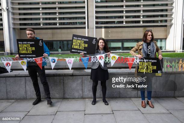 Activists hold up a giant paper chain and placards during a demonstration in front of the Home Office on March 30, 2017 in London, England. Amnesty...