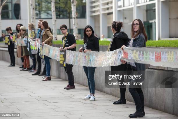 Activists hold up a giant paper chain and placards during a demonstration in front of the Home Office on March 30, 2017 in London, England. Amnesty...