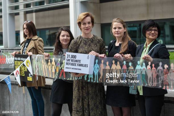 British actress Juliet Stevenson is joined by activists as they hold up a giant paper chain during a demonstration in front of the Home Office on...