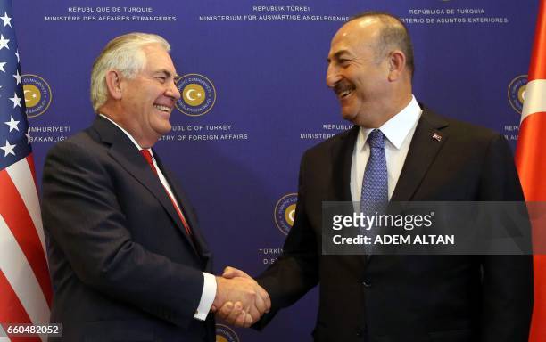 Secretary of State Rex Tillerson and Turkish Foreign Minister Mevlut Cavusoglu smile as they shake hands in Ankara on March 30, 2017. US Secretary of...