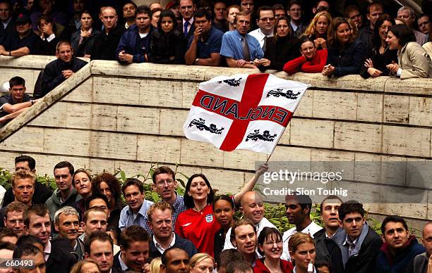 Fan of England's soccer team waves the national flag during the World Cup soccer match between England and Argentina as the game is televised on a...