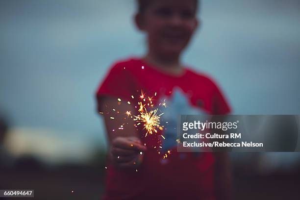 girl holding lit sparkler - cultura americana stock-fotos und bilder