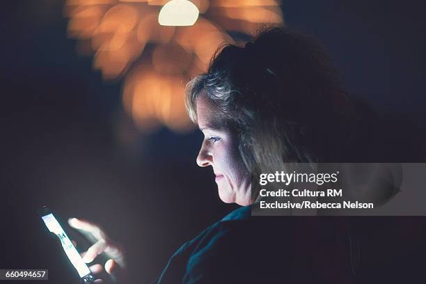 woman using smart phone during fireworks at fourth of july celebration - cultura americana stock-fotos und bilder