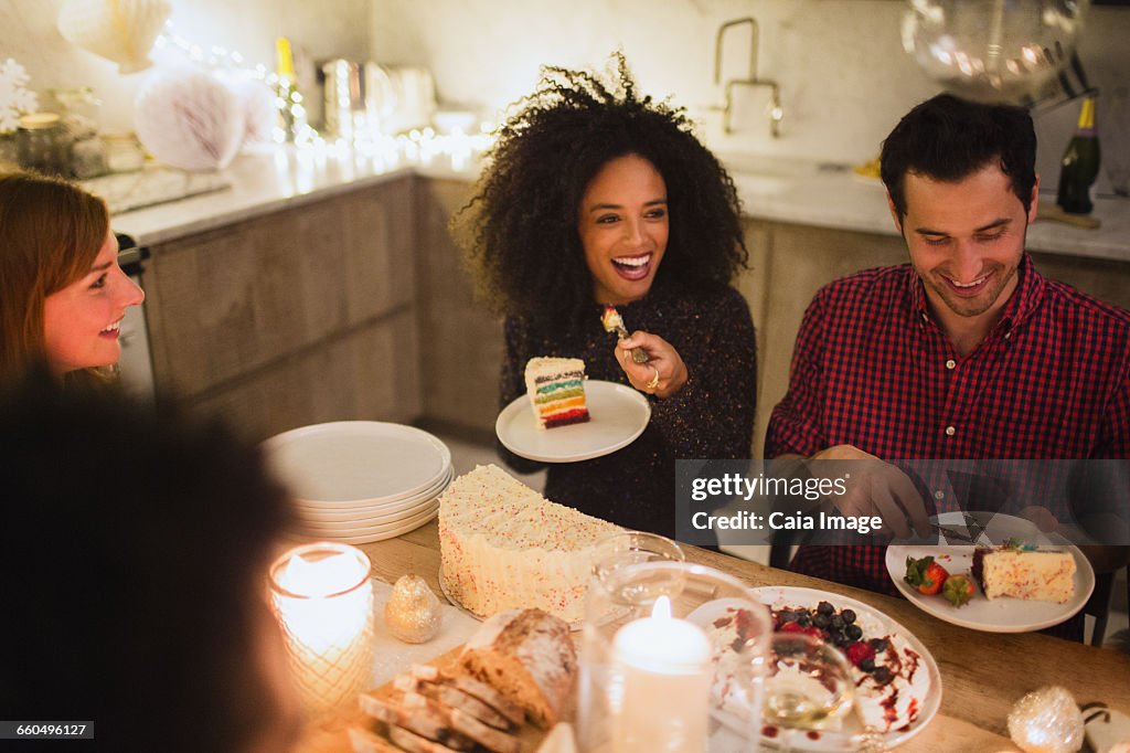 Friends eating cake at candlelight table