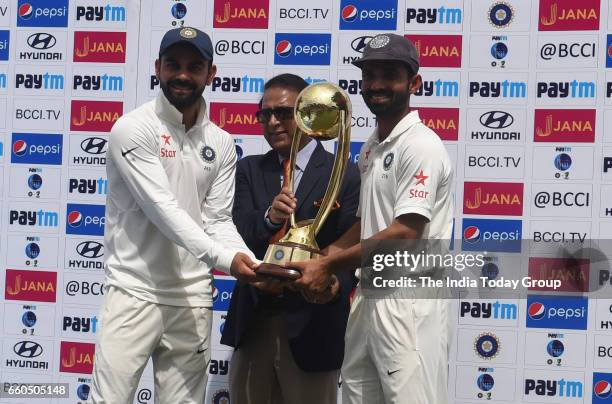 India's Virat Kohli and Ajinkya Rahane receive the trophy from the former Indian cricket player Sunil Gavaskar after winning the series during the...