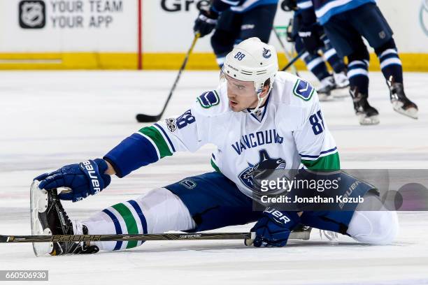 Nikita Tryamkin of the Vancouver Canucks stretches during the pre-game warm up prior to NHL action against the Winnipeg Jets at the MTS Centre on...
