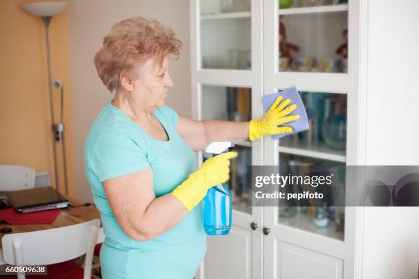 senior woman cleaning at home - yellow washing up glove stock pictures, royalty-free photos & images