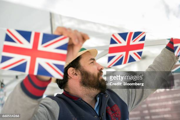 Jason Phaetos, a food vendor, hangs British union flag, or Union Jack, bunting from his mobile Cornish pastie van, Rolling Pasties, outside the...