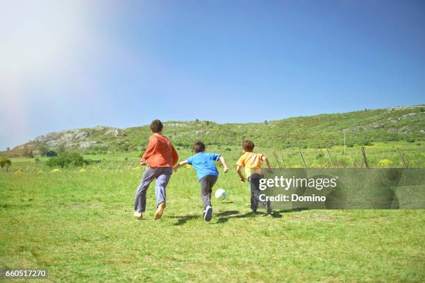 boys playing soccer outdoor, landscape - jugar stockfoto's en -beelden