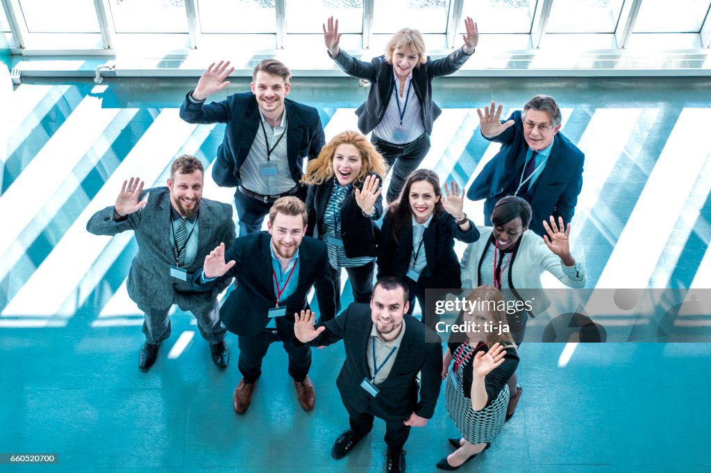 Portrait of waving business people