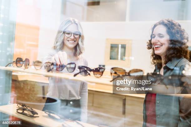 vrouw winkelen voor glazen - opticien stockfoto's en -beelden