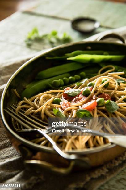 pasta de trigo integral rústico con guisantes y tomates - brycia james fotografías e imágenes de stock