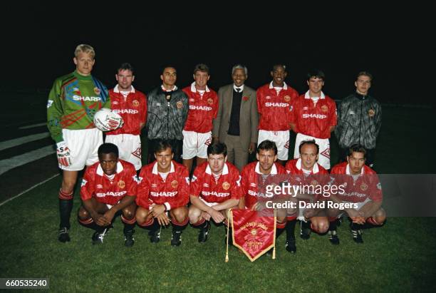 The Manchester United team line-up together for a group photograph with Nelson Mandela before a friendly match on July 28, 1993 in Johannesburg,...