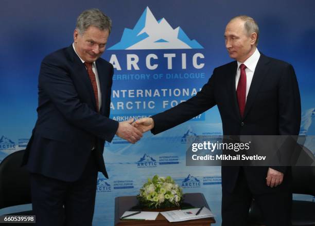 Russian President Vladimir Putin shakes hands with Finland's President Sauli Niiniste during the International Arctic Forum "Arctic: Territory of...