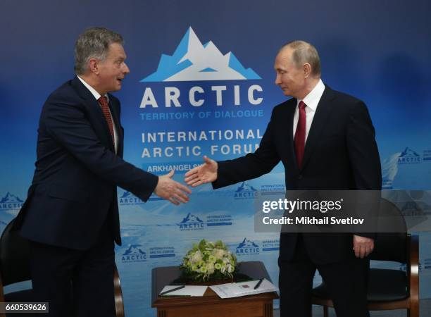 Russian President Vladimir Putin greets Finland's President Sauli Niiniste during the International Arctic Forum "Arctic: Territory of dialogue"...