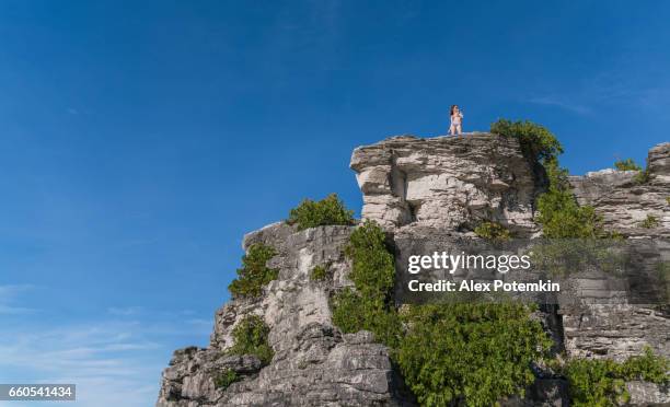 teenager girl standing on the cliff, tobermory, bruce pennisula, canada - alex grey stock pictures, royalty-free photos & images