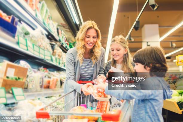 mother with son and daughter in a supermarket - shopping list trolley stock pictures, royalty-free photos & images