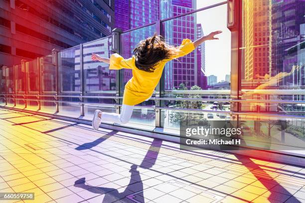 woman floating in the city - yellow blouse stockfoto's en -beelden