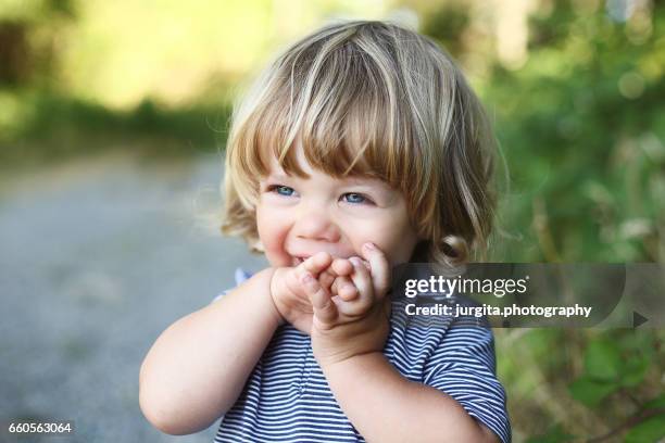 child giggling covering his mouth - bébé rire photos et images de collection