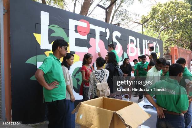 Over 40 underprivileged and differently-abled children from various NGOs and graffiti artists paint the phrase 'Let's Build Tomorrow' on a wall at...