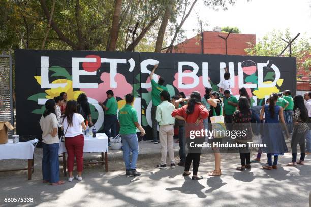 Over 40 underprivileged and differently-abled children from various NGOs and graffiti artists paint the phrase 'Let's Build Tomorrow' on a wall at...