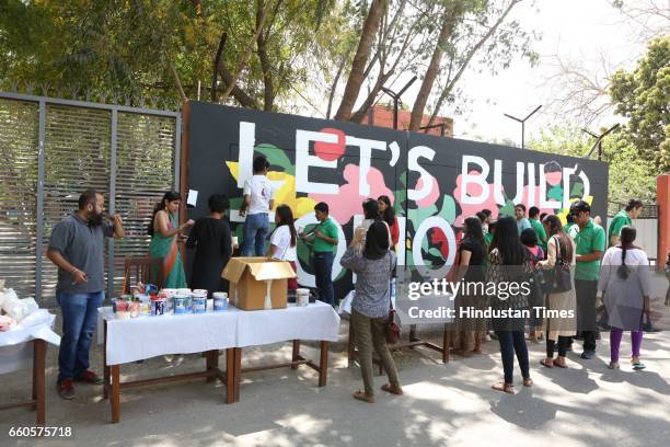 Over 40 underprivileged and differently-abled children from various NGOs and graffiti artists paint the phrase 'Let's Build Tomorrow' on a wall at...