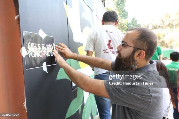 Over 40 underprivileged and differently-abled children from various NGOs and graffiti artists paint the phrase 'Let's Build Tomorrow' on a wall at...