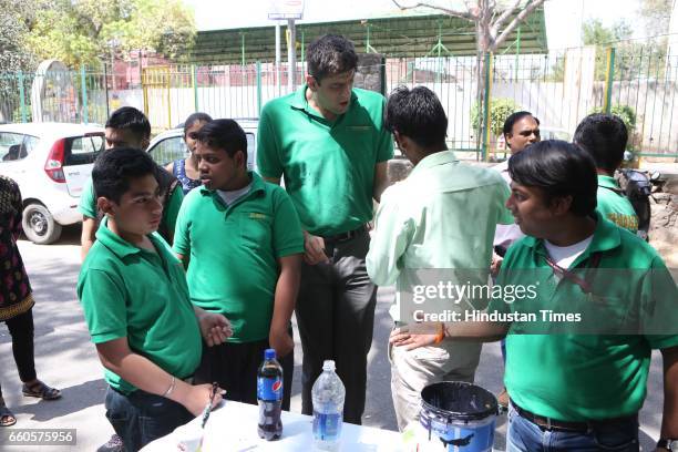 Over 40 underprivileged and differently-abled children from various NGOs and graffiti artists paint the phrase 'Let's Build Tomorrow' on a wall at...