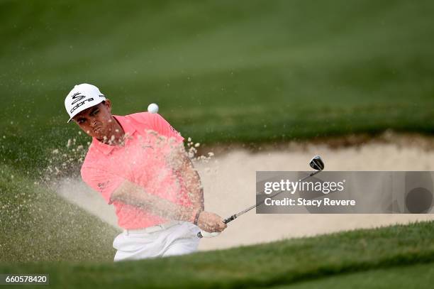 Rickie Fowler hits his third shot from a greenside bunker on the 15th hole during the first round of the Shell Houston Open at the Golf Club of...