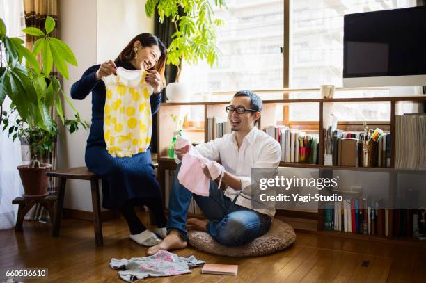 zwangere vrouw met haar man in de kamer - mid adult couple stockfoto's en -beelden
