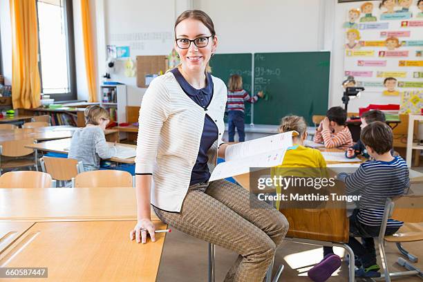 primary school teacher in front of her class - primary school teacher stock-fotos und bilder