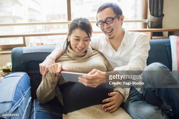 pregnant woman with her husband in room - the japanese wife stock pictures, royalty-free photos & images