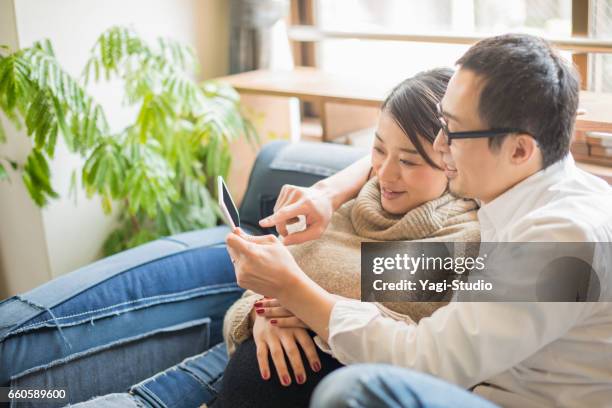 pregnant woman with her husband in room - asian married stock pictures, royalty-free photos & images